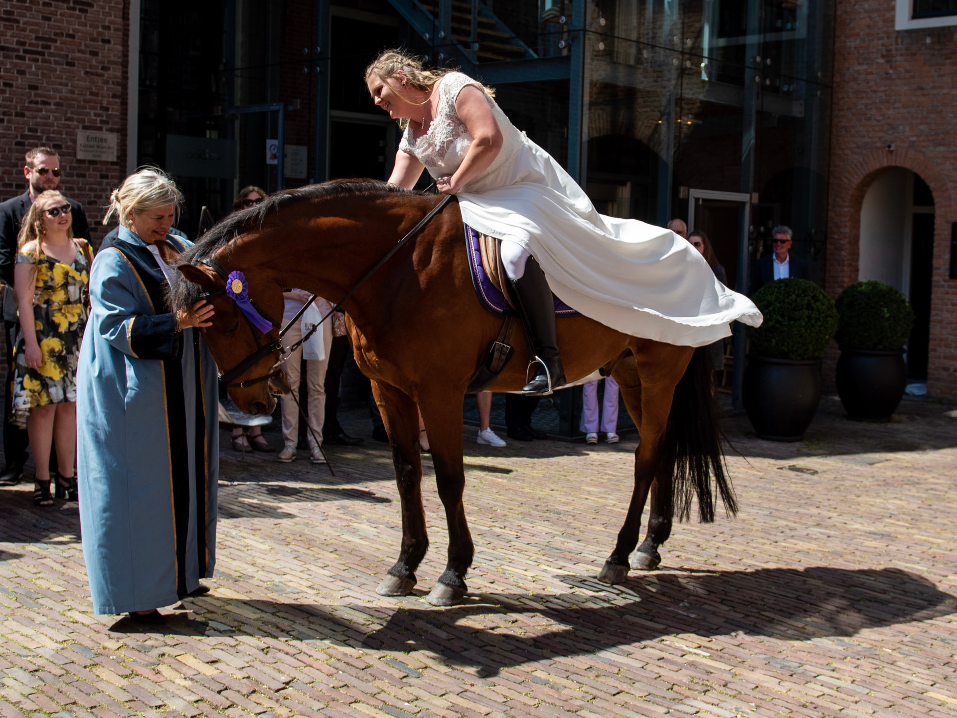 Esther begeleidt een bruid te paard voor het stadhuis